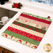 The completed Dry Ideas mat colored in festive fabrics from the Holiday Cheer collection by Moda Fabrics, staged on a white marbled kitchen countertop beside a sink.