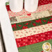 A close up on the mat demonstrating fabric prints and color details; two glasses sit in the upper left corner, showing scale.