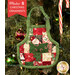 A completed Christmas Apron Ornament, colored in Christmas themed prints from the Holiday Cheer collection by Moda Fabrics, hung on a decorated Christmas tree. A small chocolate Santa peeks out of the dimensional front pocket.