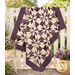 The completed Playing Favorites Quilt colored in rich cream and purple fabrics from the Plumberry Farm collection by Marcus Fabrics, artfully draped over a white fence and staged with coordinating décor.