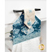 An angled close up on the top of the towel, demonstrating fabric colors on the prints and fabric button.