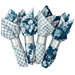 The four completed cloth napkins, colored in cream and blue fabrics from the Special Delivery collection by Andover Fabrics, isolated on a white background. 