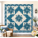 The completed Cactus in the Cabin quilt, colored in cream and blue fabrics from the Special Delivery collection by Andover Fabrics. The quilt is hung on a cream shiplap wall and staged with coordinating furniture and décor.