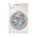Cross-stitch pattern of a colorful bunch of wildflowers framed in a circular hoop against a multicolor dotted background from Lella Boutique.