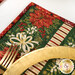 A super close up on the placemat, showing details on the fabrics used. A coordinating plate and fork peek into frame.