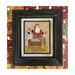 Home for Christmas finished cross stitch pattern in a weathered black frame hung on a Christmas themed wall.