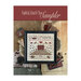 Finished Faithful, Kind & True cross stitch pattern in a black frame on top of an assortment of household items and a wooden bowl.