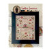 Finished Spotless Innocence cross stitch pattern, with florals surrounding trees, birds, deer, a dog, a red manor, and sampler text on a cream linen in a black frame.