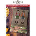 Front of the finished Autumn Scarecrows pattern on a small decorative pillow next to a pile of corn kernels and corn on the cob.