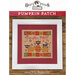 Front cover of the finished Pumpkin Patch pattern with three black cats playing around pumpkins bordered by a red and white dotted fabric in a white frame.