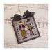 Finished Mr. & Mrs. Dracula cross stitch pattern with two vampires in their aristocratic colors surrounded by hearts and bats in a black frame with a black bow on top.