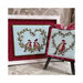 Finished Winter Robin cross stitch patterns in frames on a red fabric.