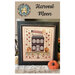 front cover of the Harvest Moon pattern featuring a autumn-themed colonial house finished and framed as home decor.