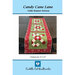 Front cover of the Candy Cane Lane table runner pattern with the runner in green and red hanging off the edge of a wooden table.