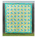 Finished Cornerstones quilt in a turquoise and yellow fabrics hung on a wooden fence.