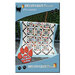 The front of the Proximity pattern with the completed quilt displayed hanging over a fence.