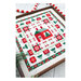 Dynamic photo of the finished Holly Lane cross stitch pattern in a wooden frame on white herringbone planks surrounded by Christmas motifs.