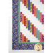 A close up on the patchwork of the quilt, demonstrating fabric colors and print details.