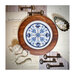 Top-down shot of the Porcelain Stitches No. 1 cross stitch pattern in a rich wooden circle hoop surrounded by a vintage inspired scene.
