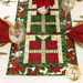 A close up on one end of the runner, showing patchwork details on the present blocks and poinsettia border.