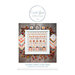 Front cover of the finished Pumpkin Hollow cross stitch pattern inside of a white frame surrounded by small pumpkins, fabrics from Moda's Birch and Willow fabric line, and smaller accent pillows.