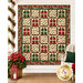 The completed A Gift for You Quilt, colored in red, green, and white, and gold metallic fabrics from the Poinsettias at Christmas collection by Jennifer Bosworth for Riley Blake Designs, staged on a white shiplap wall with coordinating furniture and décor.