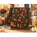 The completed Autumn Harvest Flannel Rag Quilt, colored in warm autumnal flannels from the Primo Plaids Rich & Rustic collection by Marcus Fabrics, artfully draped over a wooden bench on a sunlit porch, staged with coordinating décor and pumpkins.