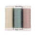 Three spools of cream, dusty blue, and dusty rose pink thread, isolated on a white background. 