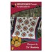 The front of the Nestfeathers pattern with the completed quilt displayed over a white picket fence.