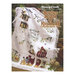 Front cover of the Scatter Seeds of Kindness Collectors' Series Throw cross stitch pattern showing the finished throw draped over wooden crates with a decorative rabbit sitting on the edge of the throw.