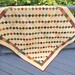 Image of finished Simplicity quilt in warm accenting colors against cream.