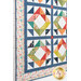 A close up on the lower left corner of the quilt, demonstrating patchwork layout details on the diamond blocks, borders, and binding.