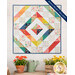 The completed bonus project, a charming wall hanging in a rainbow of prints, staged on a white shiplap wall above a garden table.