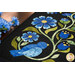 A super close up on the appliqué of the runner, demonstrating fabric colors and topstitching details on the flowers, leaves, and bird.