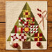 Quilted Christmas tree wall hanging with candy canes, ornaments, and a star topper.