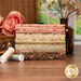 A stack of the fabrics included in the Collection for a Cause - Heirloom, with flowers and a window and a bottle and a basket and thread.