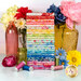 A stack of the fabrics included in the Fresh Picked Fantasy collection, with flowers and vases and jars and thread.