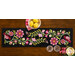 The completed Baltimore Garden Table Runner in Rose, staged on a wooden table with four black chairs and a bowl of lemons.
