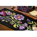 A close up on the runner, demonstrating fabric colors and details on the appliqué florals and leaves. 
