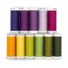 Eleven spools of purple, magenta, yellow, and green thread, isolated on a white background. 
