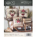 Rustic holiday pillow pattern with floral designs arranged on a wooden sled and bench.