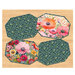 Four panel placemats in bright floral fabrics on a wooden tabletop background.