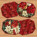 Four panel placemats in sophisticated poinsettia fabrics on a wooden tabletop background.