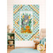 The completed Safari Snuggles Panel Quilt, colored in aqua, orange, white, and green fabrics, hung on a white shiplap wall and staged with coordinating furniture and décor.