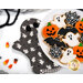 A plate of Halloween cookies shaped like ghosts, bats, pumpkins, and spider webs, staged on one of the hot pads.