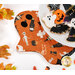 A plate of Halloween cookies shaped like ghosts, bats, pumpkins, and spider webs, staged on one of the hot pads.