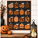 The completed Mini Pumpkins wall hanging project, colored in black, orange, and gray fabrics from the Pumpkin Grove collection by Maywood Studio, staged on a cream shiplap wall and staged with coordinating Halloween décor.