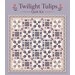 Mockup of the completed Twilight Tulips quilt, a patchwork project in cream, dusky purple, blue, and pink on a purple background
