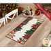 The completed A Gift for You runner colored in red, cream, and mint green fabrics from the Evergreen Wishes collection by Riley Blake Designs, staged on a wooden table with coordinating plates and flowers in a room decorated for Christmas. 