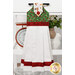 The completed Hanging Towel colored in red, green, and white fabrics from the Barnyard Christmas collection by Northcott Fabrics, staged on a kitchen drawer with coordinating decor.